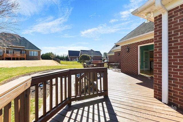 wooden deck featuring a lawn