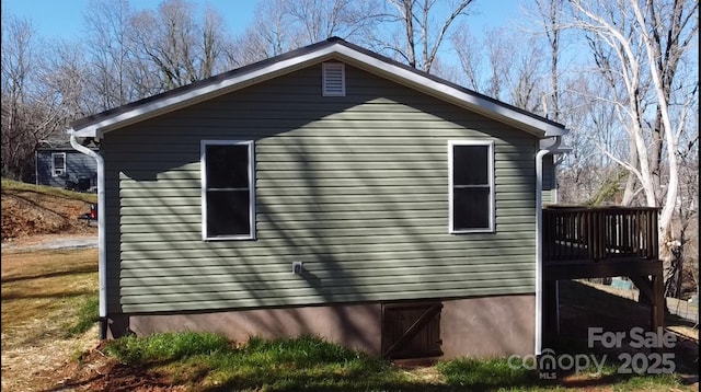 view of side of property featuring a wooden deck