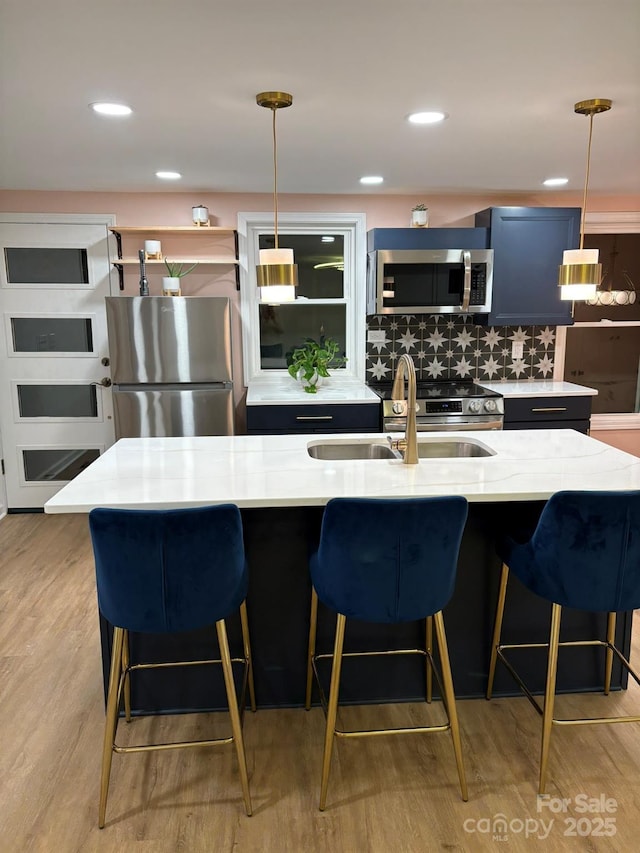 122 Lane St, Morganton, NC 28655 - kitchen featuring stainless steel appliances, a sink, pendant lighting, tasteful backsplash, and light wood-style floors
