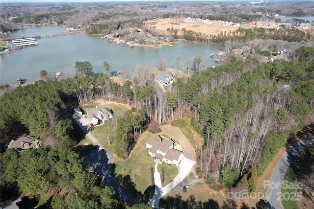 drone / aerial view with a water view and a wooded view