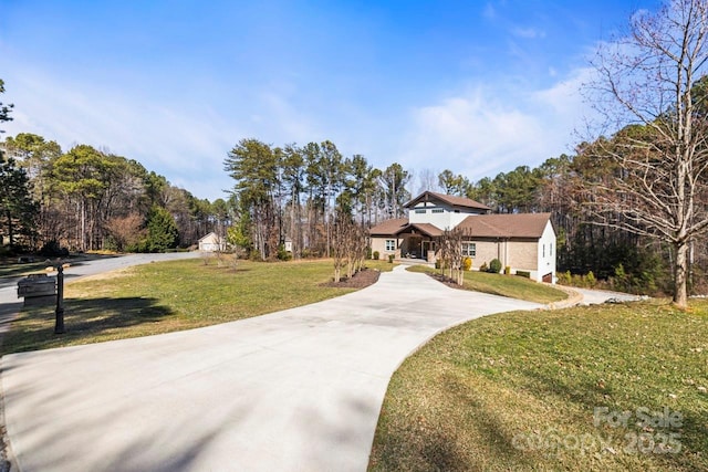 view of front of home with concrete driveway and a front lawn