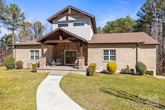 view of front of house with brick siding, roof with shingles, and a front yard