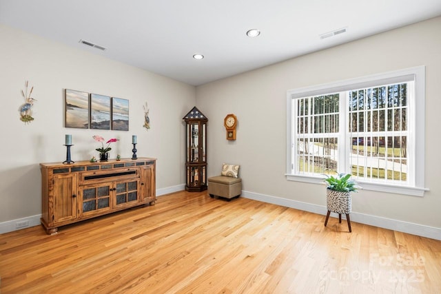 living area featuring light wood-style floors, recessed lighting, visible vents, and baseboards