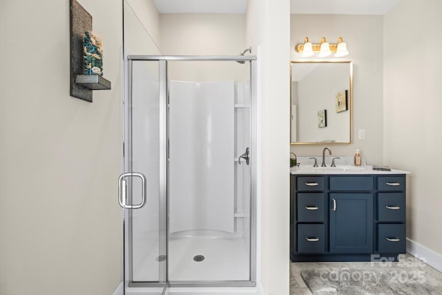 full bathroom featuring a stall shower, vanity, and baseboards