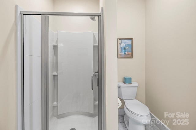 bathroom with a stall shower and toilet