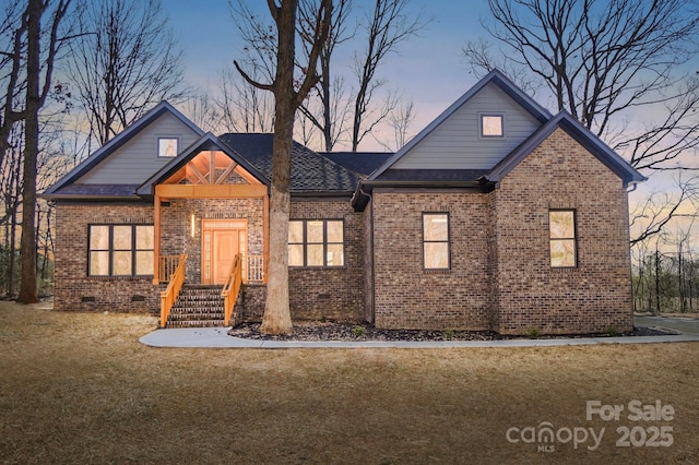 view of front of home featuring brick siding, crawl space, a front yard, and a shingled roof