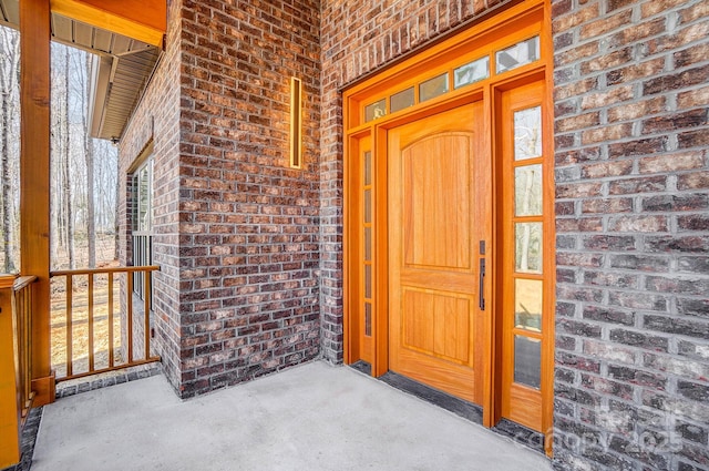 doorway to property with brick siding