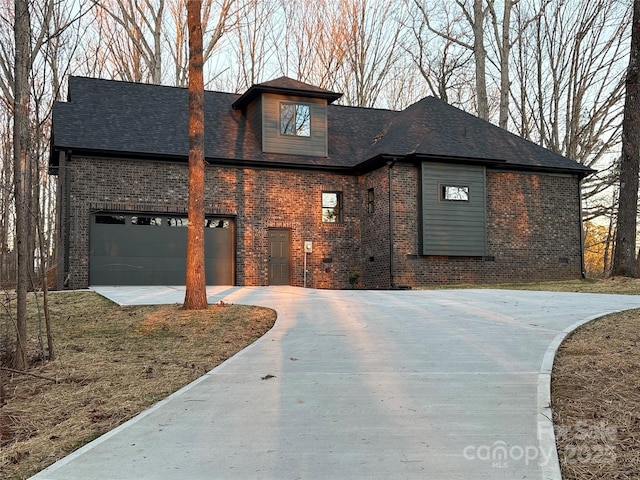 view of front of property featuring a garage, roof with shingles, concrete driveway, and brick siding