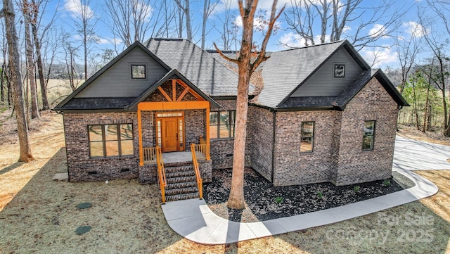 view of front of house featuring a shingled roof and brick siding