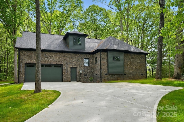 view of front of house with brick siding, a garage, a front lawn, and concrete driveway