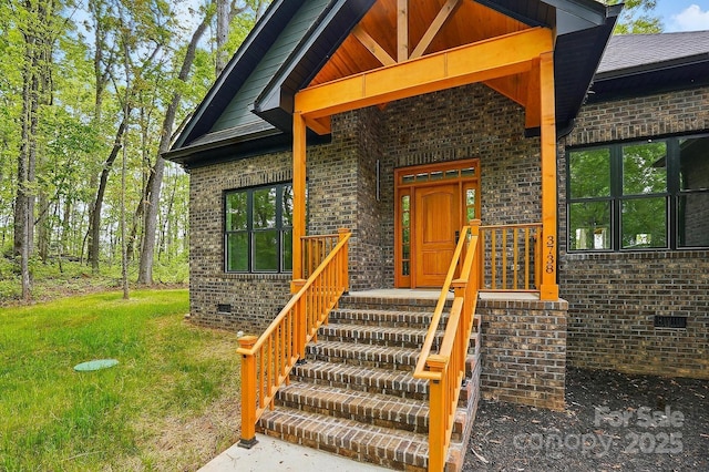 doorway to property with a lawn, brick siding, and crawl space