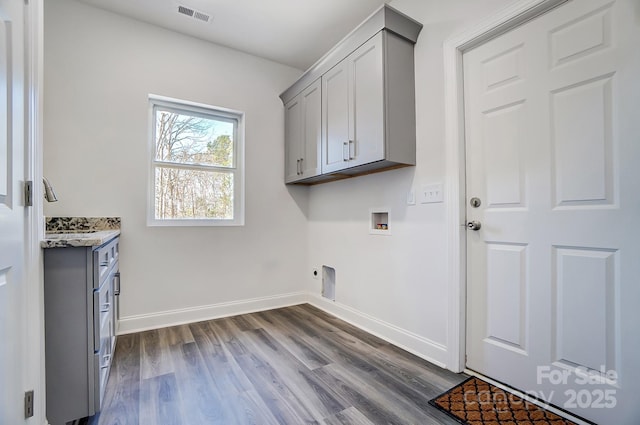 washroom featuring visible vents, dark wood finished floors, electric dryer hookup, cabinet space, and washer hookup