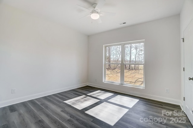 unfurnished room featuring baseboards, ceiling fan, dark wood-style flooring, and visible vents