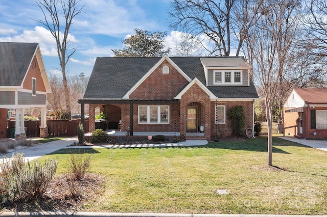 view of front of property featuring a front yard, brick siding, and fence