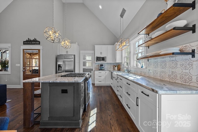 kitchen with white cabinets, appliances with stainless steel finishes, a center island, dark wood-style floors, and open shelves