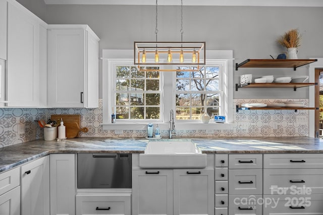 kitchen with a sink, stainless steel dishwasher, white cabinetry, open shelves, and backsplash