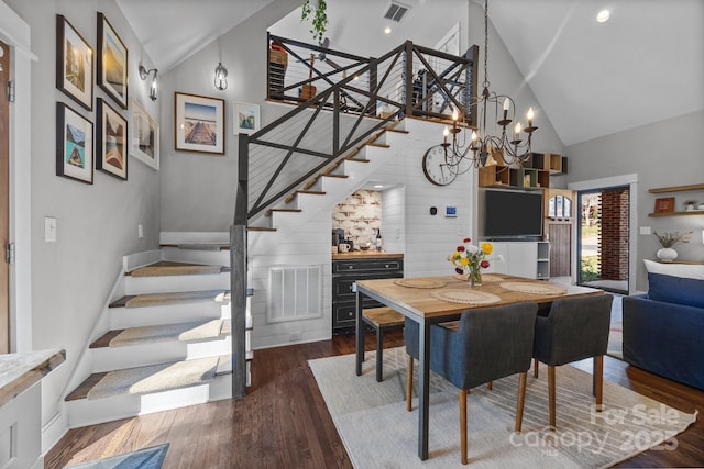 dining room with high vaulted ceiling, stairs, visible vents, and wood finished floors