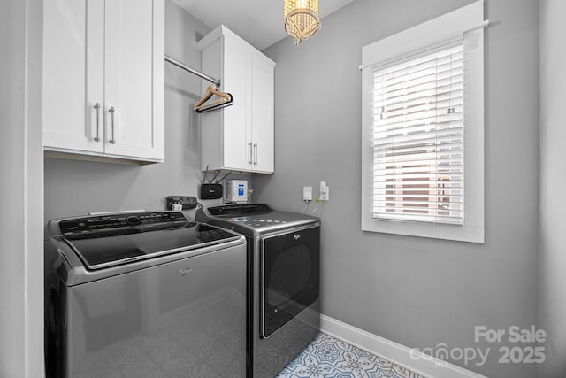 clothes washing area with independent washer and dryer, cabinet space, and baseboards