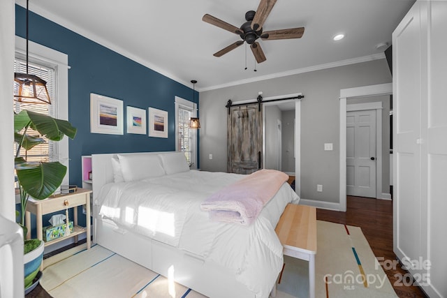 bedroom with recessed lighting, a barn door, ornamental molding, wood finished floors, and baseboards