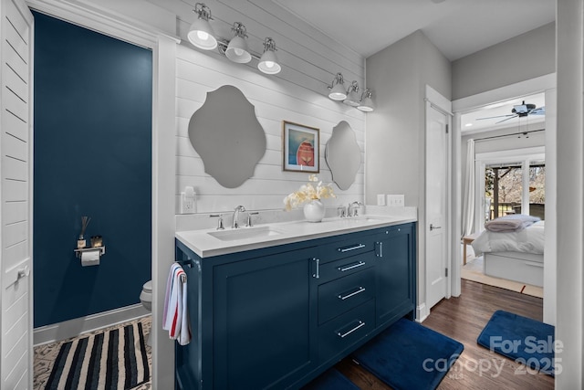 full bath featuring ceiling fan, wood finished floors, a sink, and ensuite bathroom