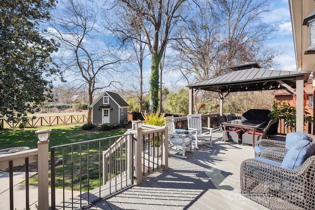 deck featuring an outbuilding, fence, a gazebo, a yard, and a shed