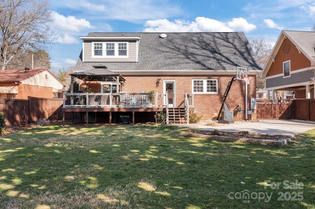 back of house featuring brick siding, a yard, a gazebo, a fenced backyard, and a wooden deck