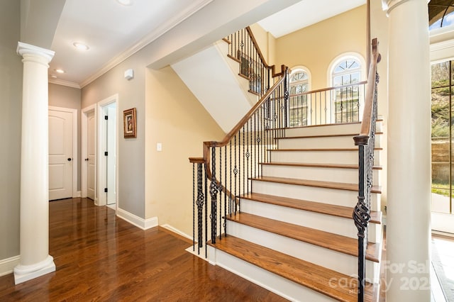 stairway featuring crown molding, baseboards, decorative columns, recessed lighting, and wood finished floors