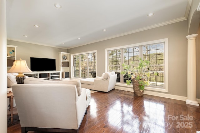 living area featuring a wealth of natural light, dark wood finished floors, and ornate columns