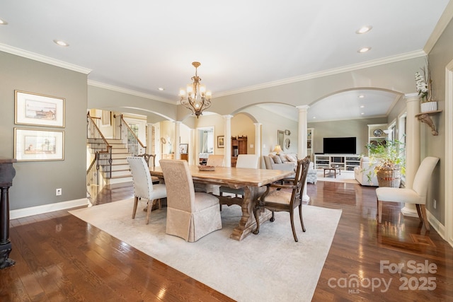 dining room featuring dark wood-type flooring, baseboards, stairs, decorative columns, and a wealth of natural light