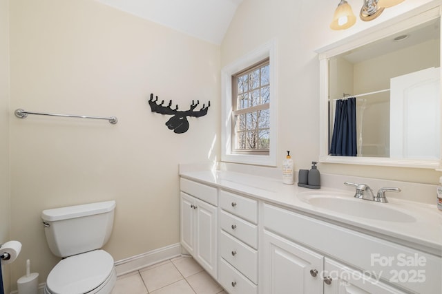 bathroom featuring toilet, a sink, tile patterned flooring, double vanity, and lofted ceiling