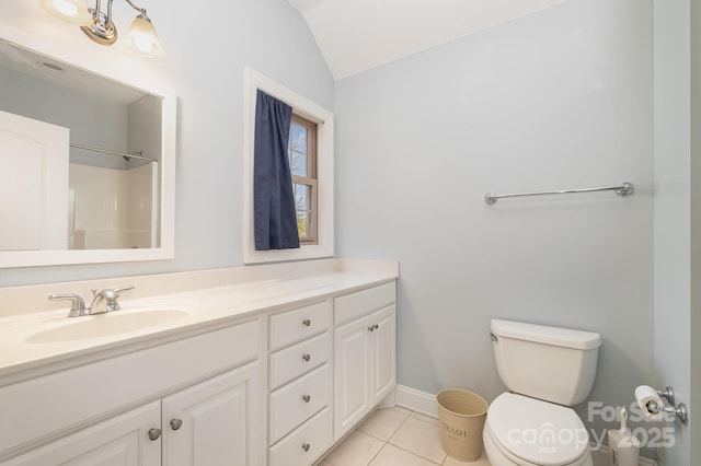 bathroom featuring tile patterned floors, toilet, lofted ceiling, baseboards, and vanity