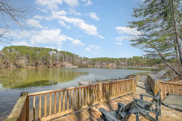 view of dock featuring a forest view and a water view