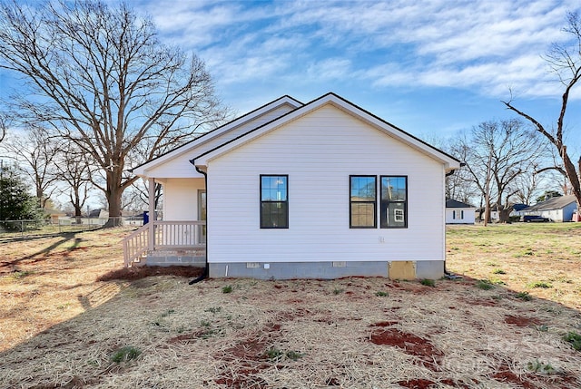 view of side of home with crawl space and fence