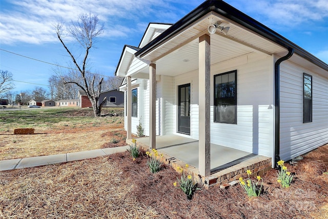 view of side of home with covered porch