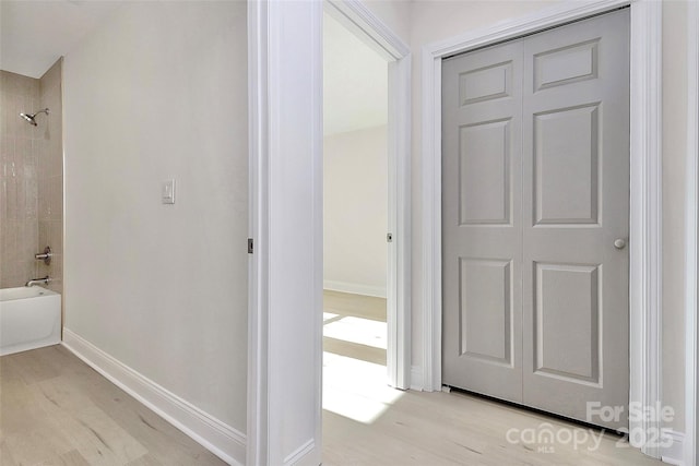 hallway with light wood finished floors and baseboards