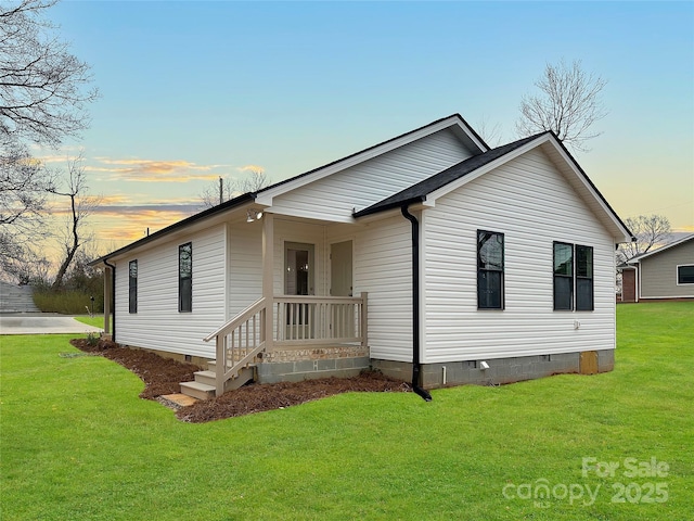 view of front of property featuring crawl space and a lawn