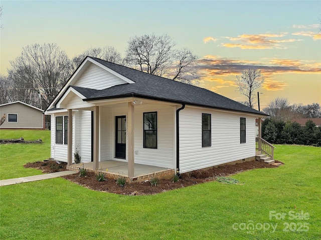 view of front of home featuring a lawn and a shingled roof