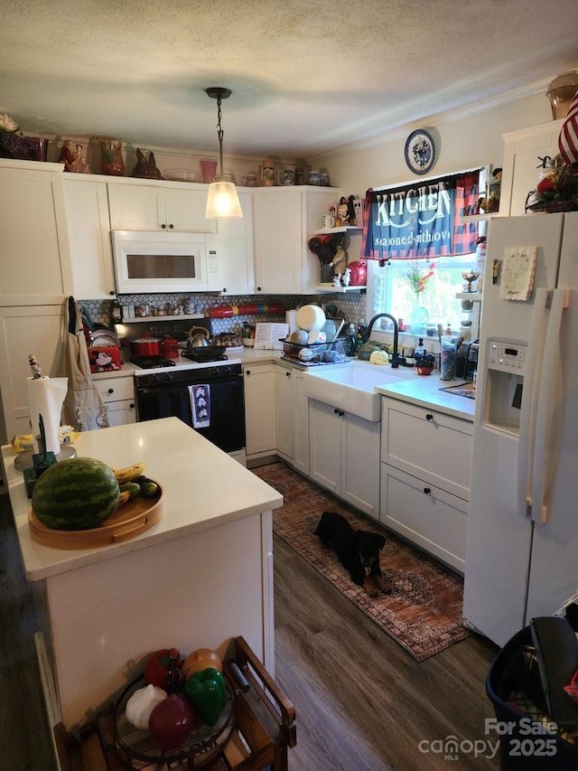 kitchen with a textured ceiling, white appliances, dark wood-style flooring, a sink, and white cabinetry