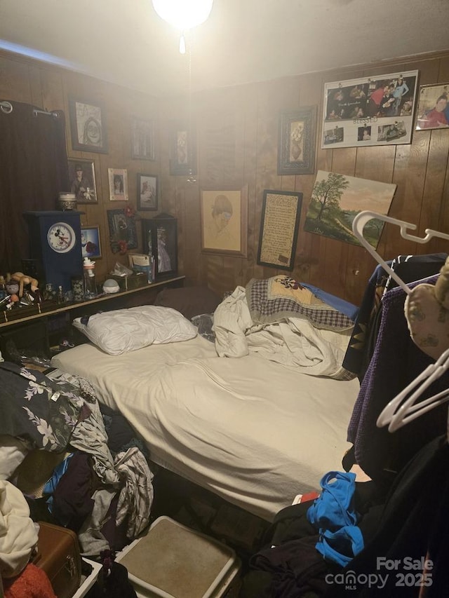 bedroom featuring wooden walls