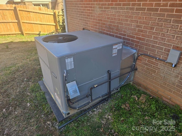 details with cooling unit, brick siding, and fence