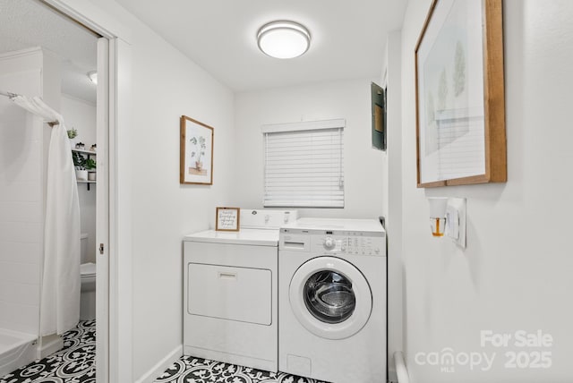 washroom with laundry area, washer and clothes dryer, and baseboards