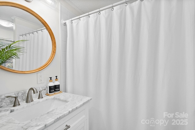 full bathroom with a textured ceiling and vanity