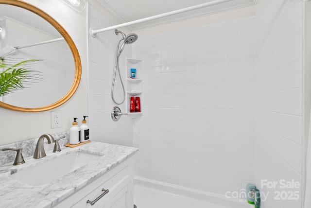 bathroom featuring a tile shower and vanity