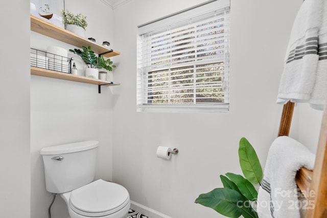 bathroom featuring baseboards and toilet