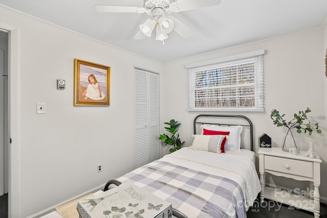 bedroom featuring baseboards, ceiling fan, ornamental molding, and a closet