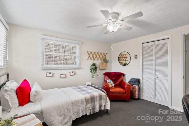 bedroom featuring a textured ceiling, carpet floors, a closet, and a ceiling fan