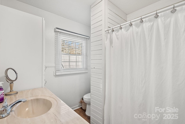 full bath featuring wood finished floors, a sink, toilet, and curtained shower