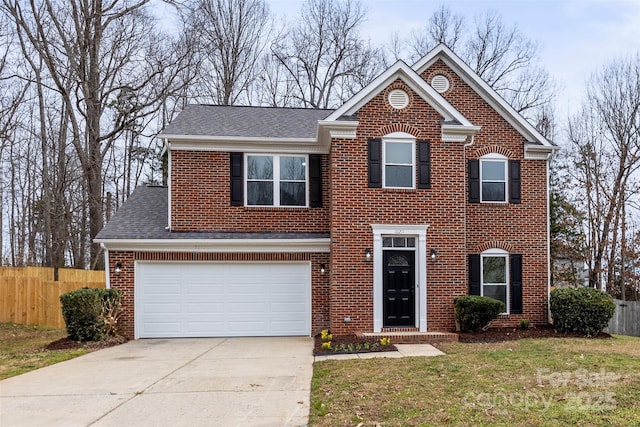 traditional home with a front lawn, driveway, fence, an attached garage, and brick siding