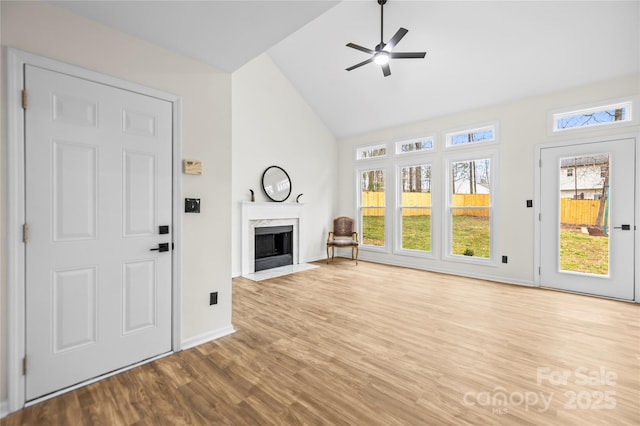 unfurnished living room with a premium fireplace, a healthy amount of sunlight, and wood finished floors