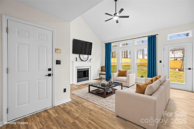 living room with lofted ceiling, a ceiling fan, wood finished floors, and a fireplace